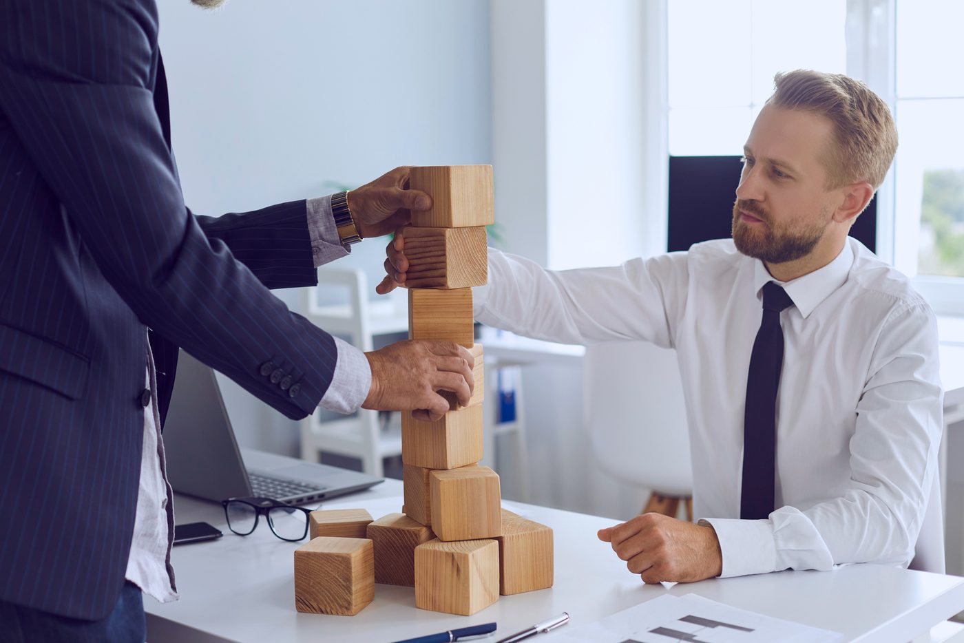 Equipo de trabajo construyendo una torre de bloques de madera, metáfora del análisis de procesos